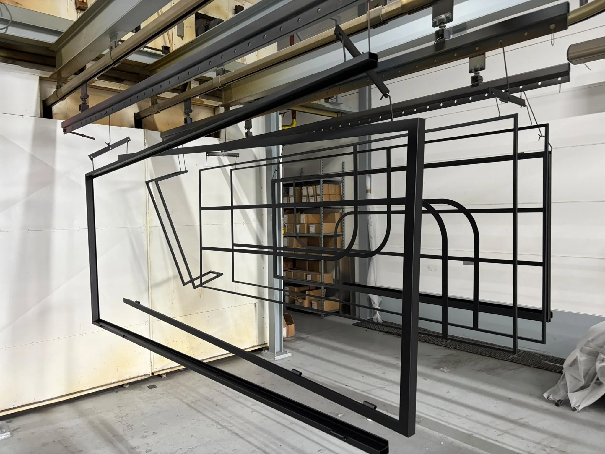 Meerdere stalen deurframes opgehangen in de coatingruimte