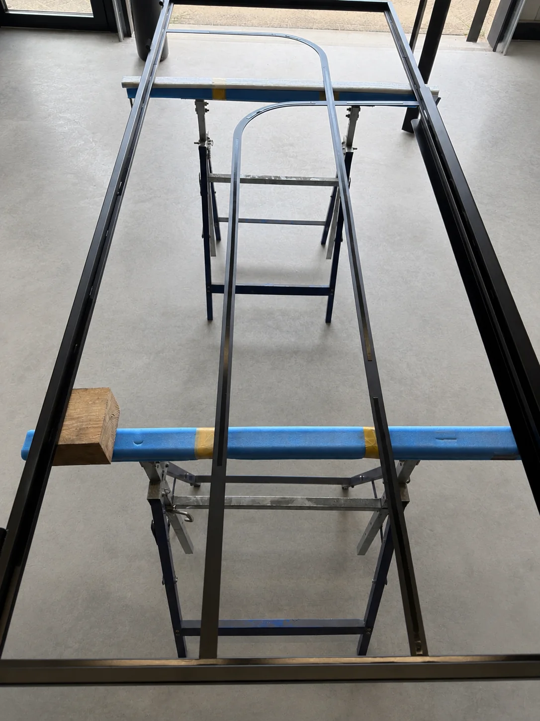 Stalen deur en glaslatten worden voorbereid voor montage op locatie