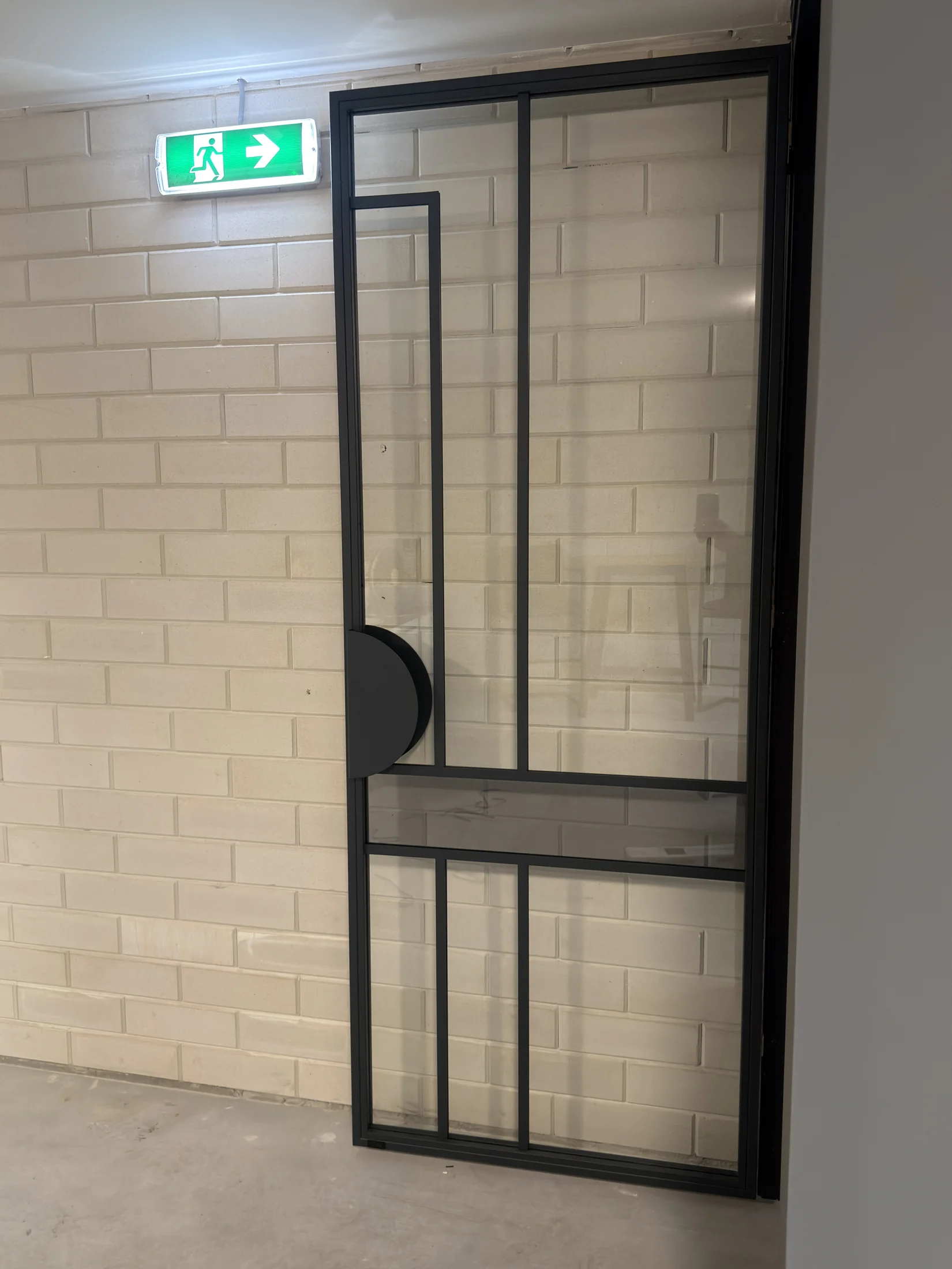 Zwarte stalen scharnierdeur met glas en vakverdeling in de showroom