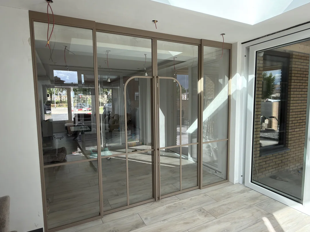 Maatwerk stalen schuifpui met helder glas in Venlo, uitgevoerd in de kleur Quartz no. 2.